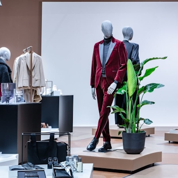 The BOSS Studio in Zurich embodies an avant-garde retail concept within a 250-square-meter space. With a nod to the brand's essence, a vibrant customisation corner and captivating window displays adorned with flashlights enchant passersby. Retail design by Studio Königshausen.